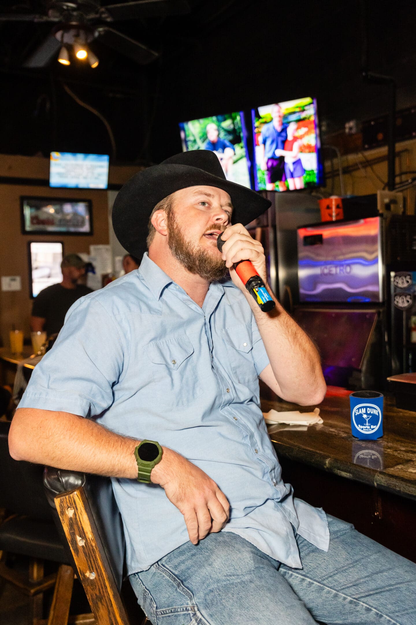 A man sitting at the bar with a microphone in his hand.